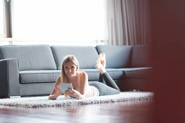 Young woman using tablet computer on the floor — Stock Photo, Image