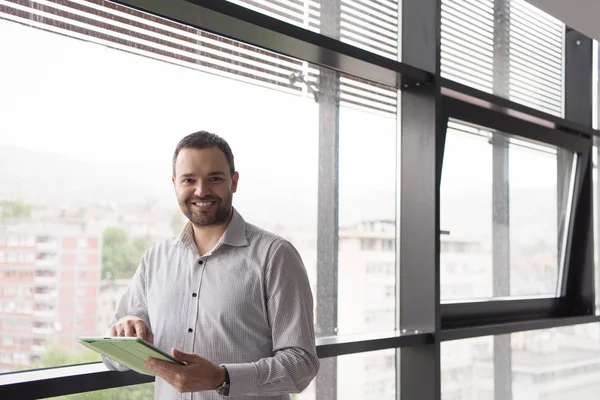 Бізнесмен за допомогою планшетного ПК у Офісна будівля вікна — стокове фото