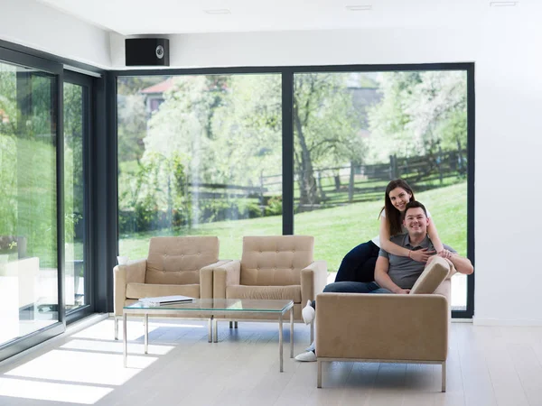 Young handsome couple hugging on the sofa — Stock Photo, Image