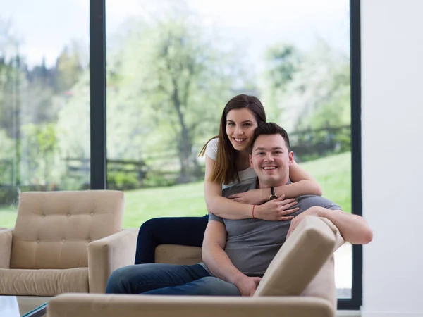 Jovem casal bonito abraçando no sofá — Fotografia de Stock