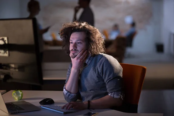 Hombre trabajando en la computadora en la oficina oscura — Foto de Stock