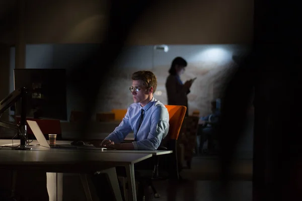 Uomo che lavora al computer in ufficio buio — Foto Stock
