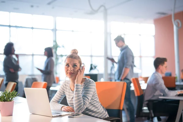 Zakenvrouw met behulp van een laptop in opstarten kantoor — Stockfoto