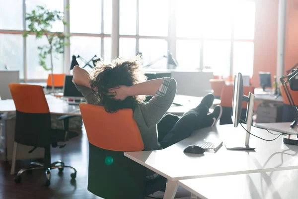 Affärsman som sitter med benen på skrivbord — Stockfoto