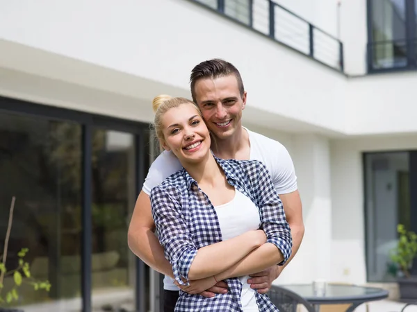 Casal abraçando na frente de nova casa de luxo — Fotografia de Stock