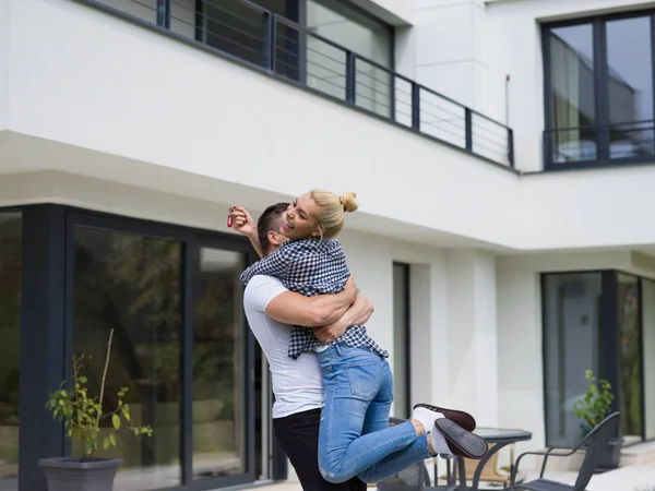 Ζευγάρι αγκαλιάζει μπροστά από το νέο πολυτελές σπίτι — Φωτογραφία Αρχείου