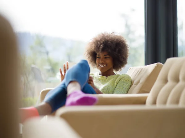 Joven afroamericana mujer en casa usando tableta digital —  Fotos de Stock