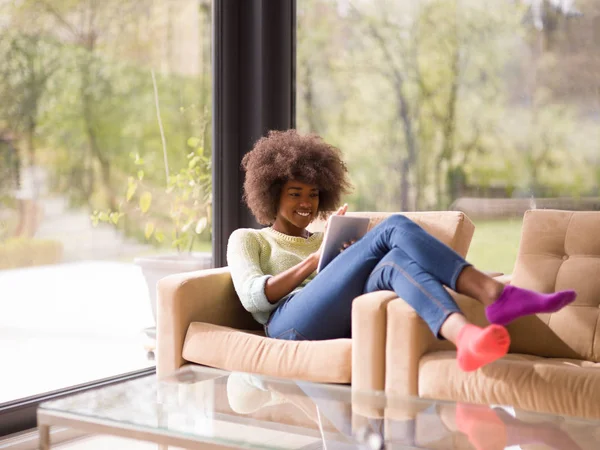 Jovem afro-americana em casa usando tablet digital — Fotografia de Stock