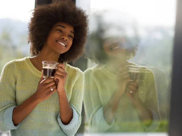 Donna afroamericana che beve caffè guardando fuori dalla finestra — Foto Stock