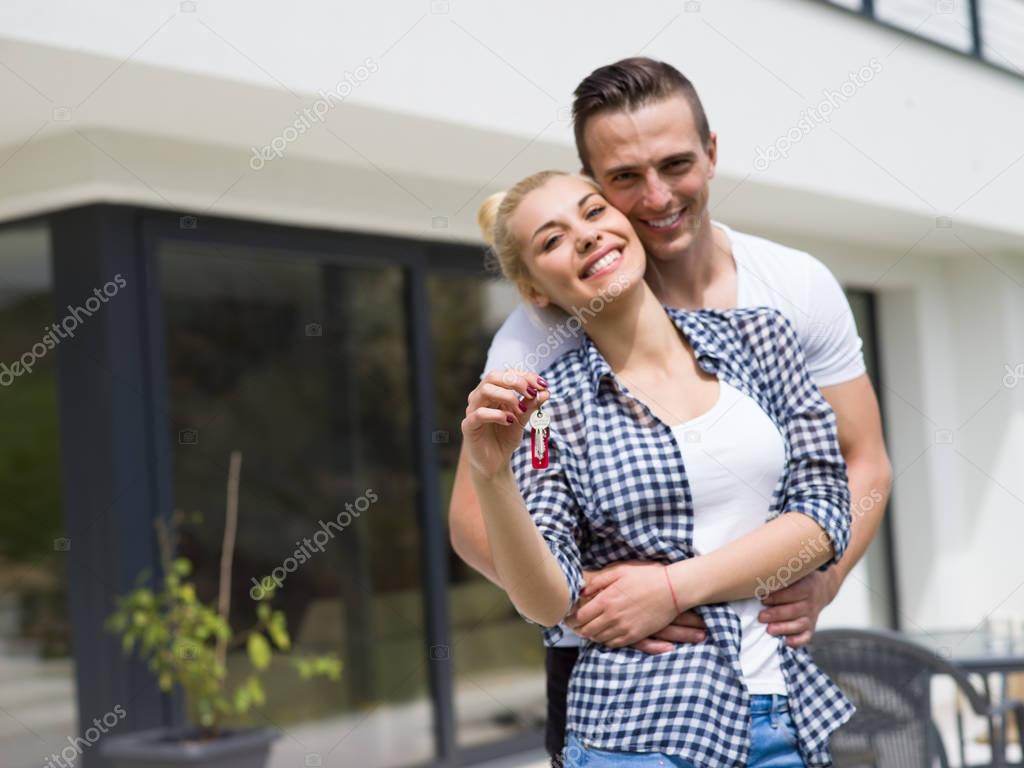 couple hugging in front of  new luxury home
