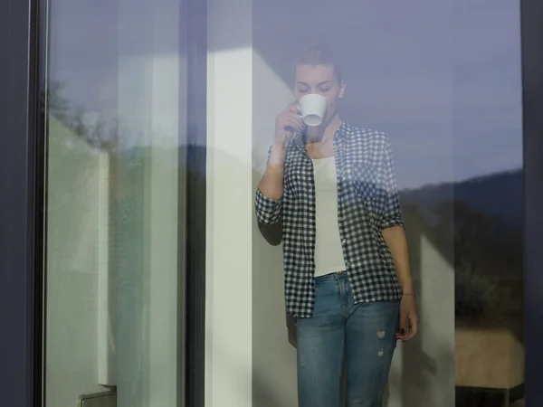 Jeune femme buvant le café du matin près de la fenêtre — Photo
