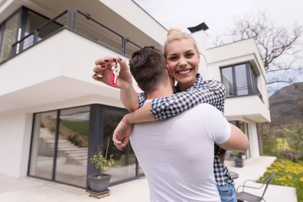 Couple étreignant devant la nouvelle maison de luxe — Photo