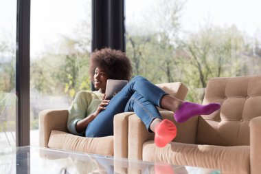 Genç Afro-Amerikan kadın evde dijital tablet kullanma