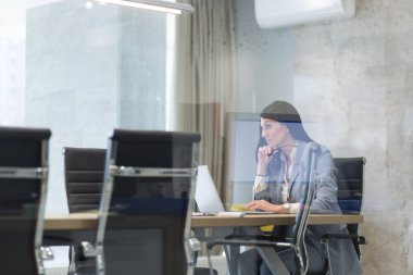 başlangıç ofisinde bir dizüstü bilgisayar kullanarak iş kadını