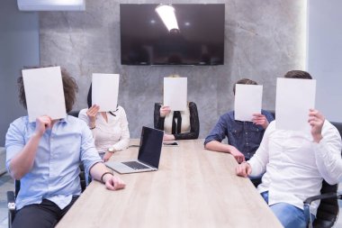 başlangıç iş ekibi beyaz bir kağıt yüz üzerinde tutarak