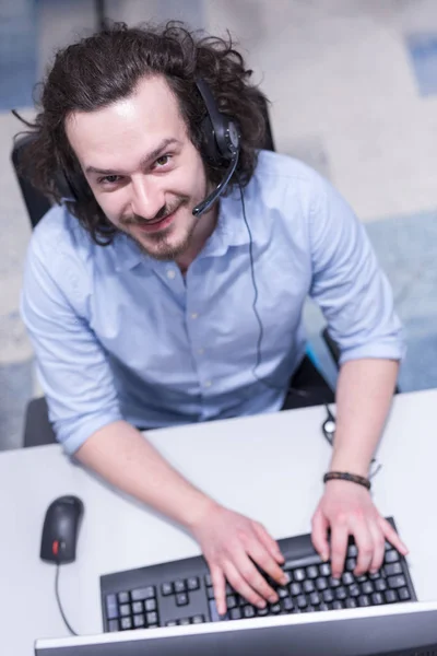 Männlicher Callcenter-Betreiber macht seinen Job von oben — Stockfoto