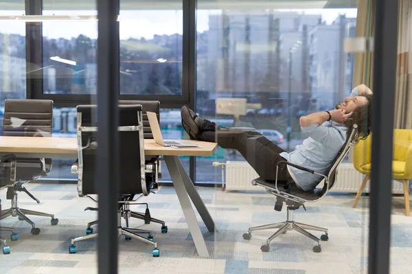 Young businessman relaxing at the desk — Stock Photo, Image