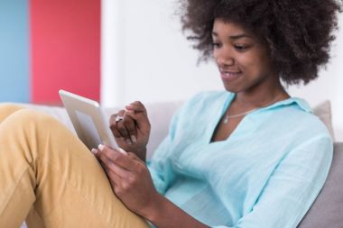 Afrikalı-Amerikalı kadın evde dijital tablet kullanma