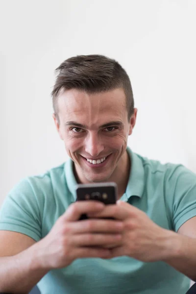 Joven usando un teléfono móvil en casa — Foto de Stock