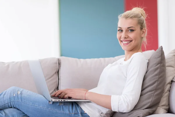 Jovem mulher usando laptop em casa — Fotografia de Stock