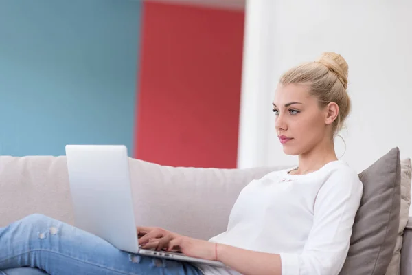 Jovem mulher usando laptop em casa — Fotografia de Stock