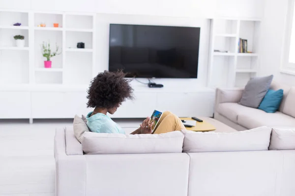 Femme afro-américaine à la maison en utilisant une tablette numérique — Photo