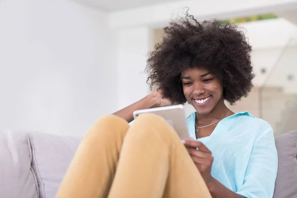 Mulher afro-americana em casa usando tablet digital — Fotografia de Stock