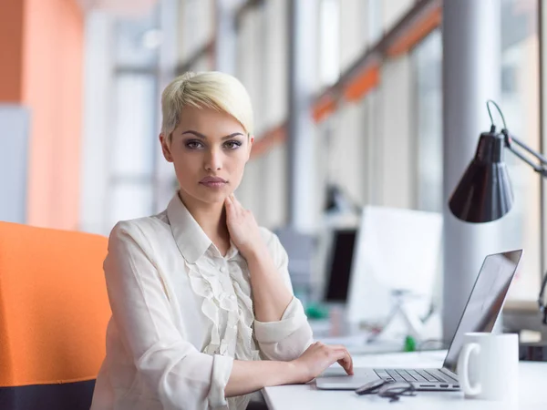 Businesswoman using a laptop in startup office — Stock Photo, Image