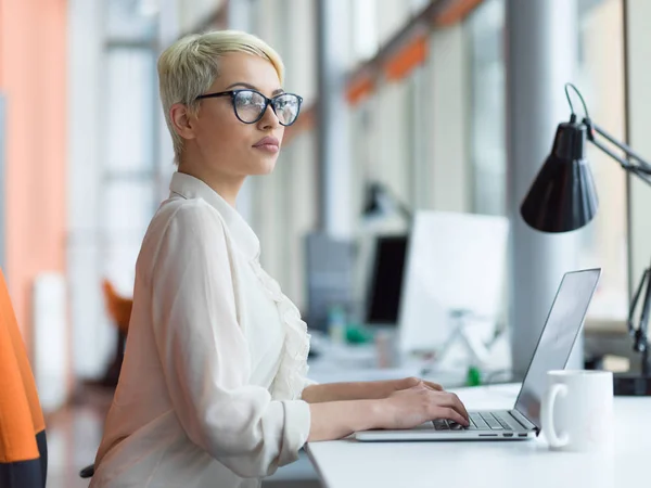 Business woman using a laptop in startup office — стоковое фото