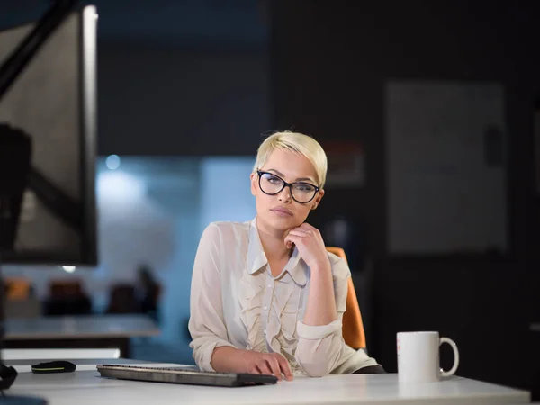 Frau arbeitet im dunklen Büro am Computer — Stockfoto