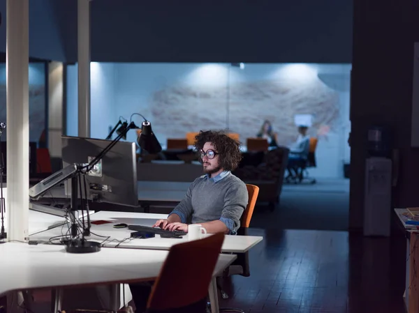 Людина працює на комп'ютері в темному стартапі — стокове фото