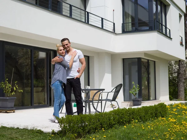 Couple hugging in front of  new luxury home — Stock Photo, Image