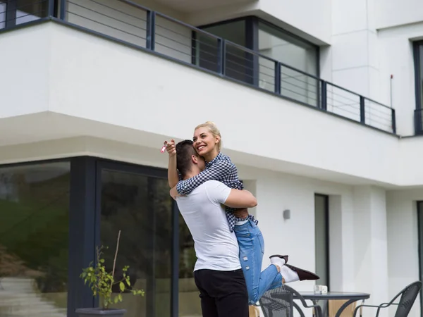 Paar umarmt sich vor neuem Luxus-Haus — Stockfoto