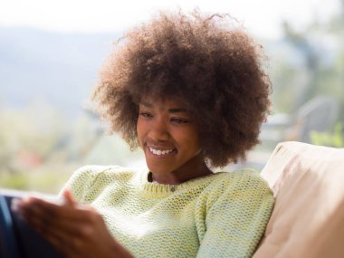 Genç Afro-Amerikan kadın evde dijital tablet kullanma