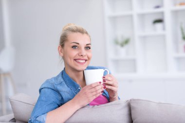 Bir fincan kahve içen bir kadın.