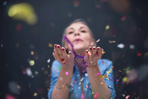 Femme soufflant des confettis dans l'air — Photo