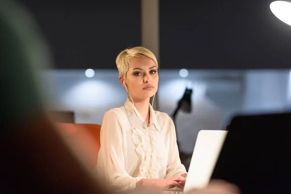 Mujer que trabaja en el ordenador portátil en la oficina de inicio de noche — Foto de Stock