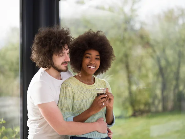Glückliches multiethnisches Paar entspannt sich im modernen Haus drinnen — Stockfoto