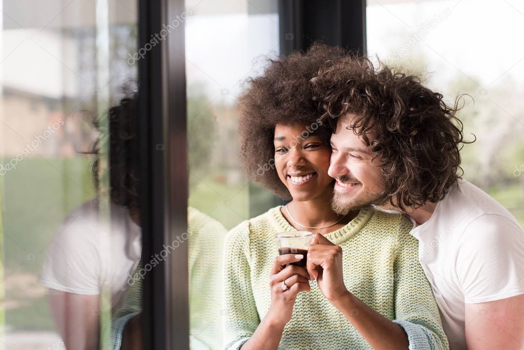 happy multiethnic couple relaxing at modern home indoors