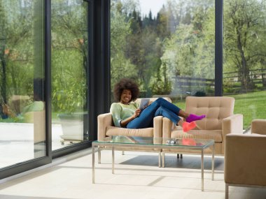 Genç Afro-Amerikan kadın evde dijital tablet kullanma