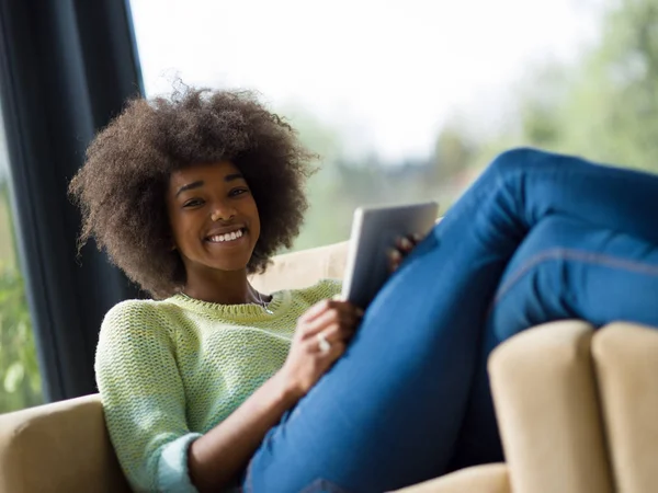 Młody african american Kobieta w domu za pomocą cyfrowego tabletu — Zdjęcie stockowe