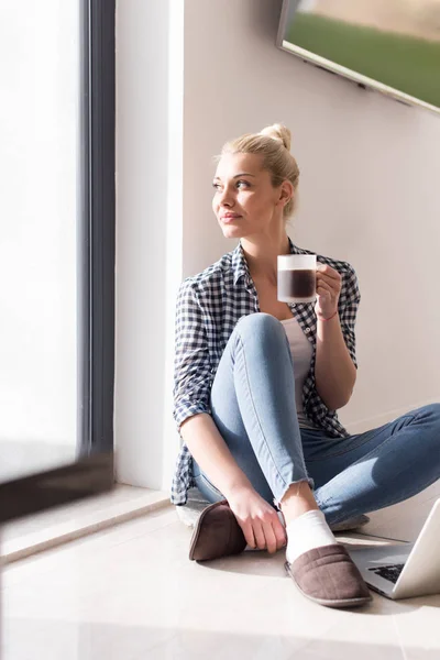 Ung kvinna dricker kaffe njuter av avkopplande livsstil — Stockfoto
