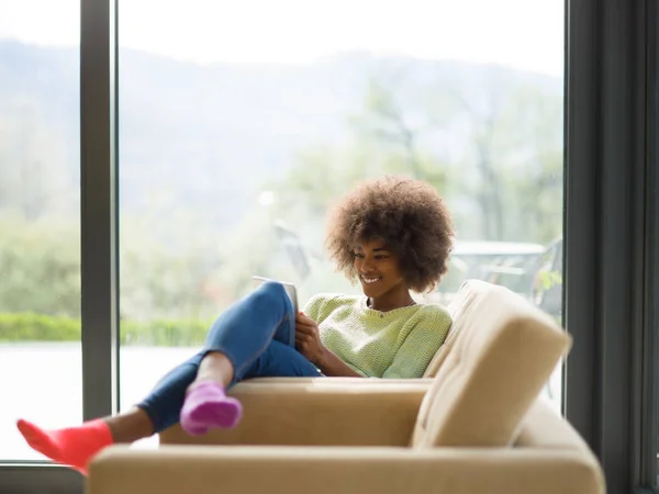 Jeune femme afro-américaine à la maison en utilisant une tablette numérique — Photo