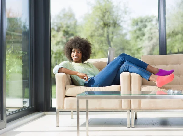 Junge afrikanisch-amerikanische Frau zu Hause mit digitalem Tablet — Stockfoto