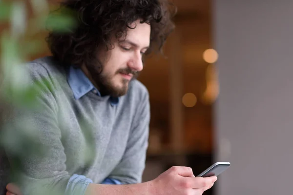 Joven hombre de negocios casual sosteniendo smartphone — Foto de Stock