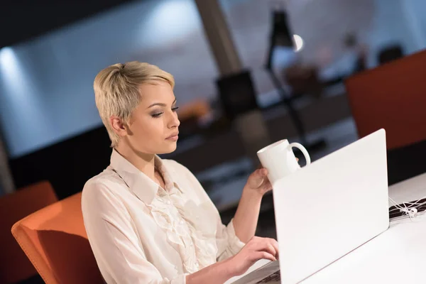 Mulher trabalhando no laptop no escritório de inicialização da noite — Fotografia de Stock