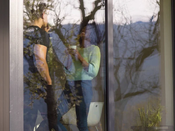 Glückliches multiethnisches Paar entspannt sich im modernen Haus drinnen — Stockfoto