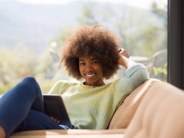 Genç Afro-Amerikan kadın evde dijital tablet kullanma