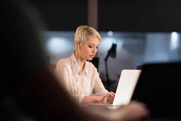 Mulher trabalhando no laptop no escritório de inicialização da noite — Fotografia de Stock