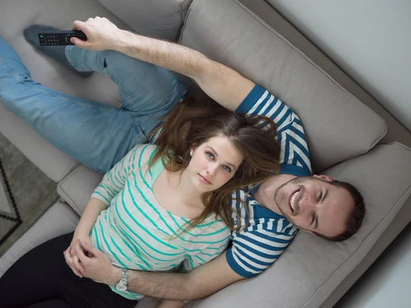 Jovem casal bonito abraçando no sofá — Fotografia de Stock